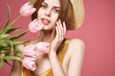 Neşeli kadın çiçek buketi hediye olarak tatil için pembe arka plan