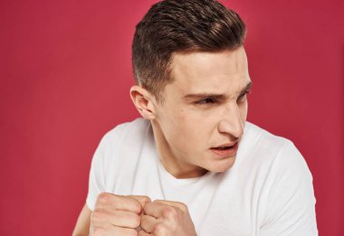 Kızgın adam yüz ifadesinden memnun değil. Kırmızı arka planı kapatın.