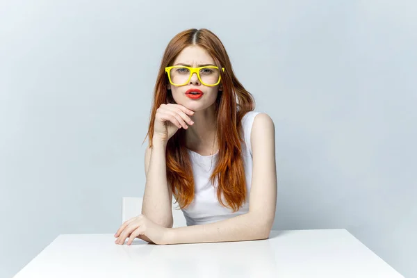 Pretty woman in white dress sitting at the table yellow glasses emotions — Stock Photo, Image