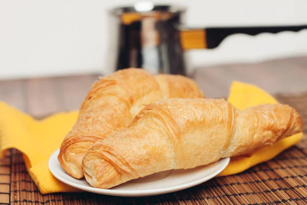 Crispy croissants on a plate kitchen utensils for breakfast — Stock Photo, Image