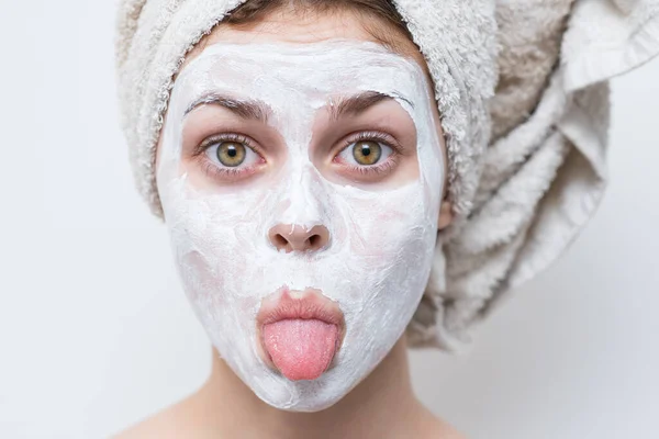 Mujer con hombros desnudos con una toalla en la cabeza cuidado de la piel máscara facial —  Fotos de Stock