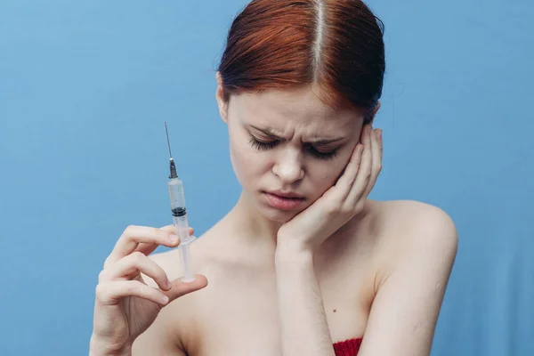 Mujer dando inyección y desnudo hombros asustado cara fondo azul — Foto de Stock