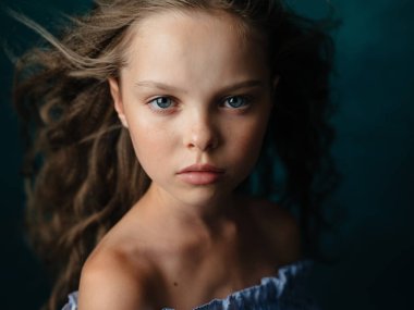 Koyu arkaplanda güzel bir kız bebek, yakın plan kesilmiş bir portre.