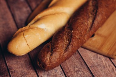 Tahta kesme tahtasında taze ekmek dilimliyorum.