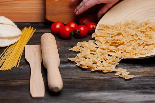 Cottura della pasta italiana a mano cucina pomodorini ingredienti pranzo — Foto Stock