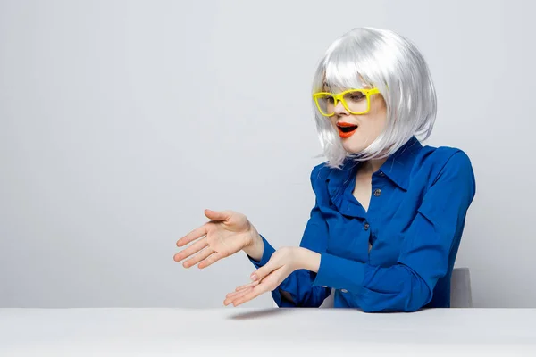 Mujer emocional en peluca blanca gesto con las manos gafas amarillas labios rojos encanto escritorio — Foto de Stock