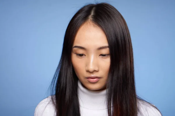 Kvinna asiatisk utseende porträtt på blå bakgrund vit tröja modell — Stockfoto