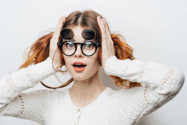 Beyaz süveter gözlüklü güzel bir kadın stüdyo çekici saçları var.