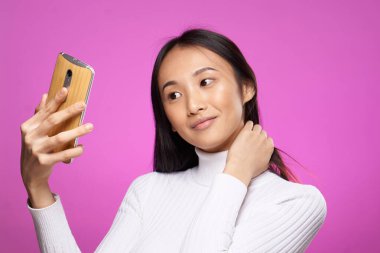 Asyalı kadın telefon tutuyor iletişim teknolojisi internet pembe arka plan