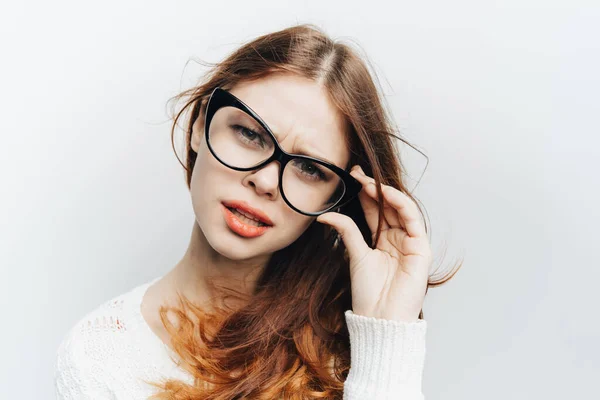 Rothaarige Frau mit modischer Brille hält Hand in der Nähe des gesichtsnahen Modells — Stockfoto