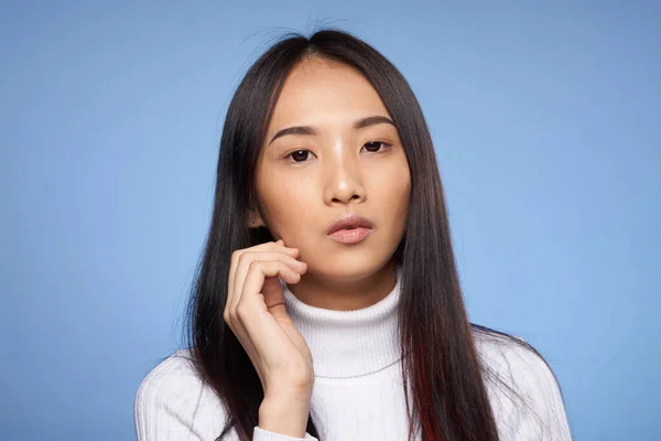 Портрет красивая азиатская женщина с темными волосами белый свитер синий фон — стоковое фото