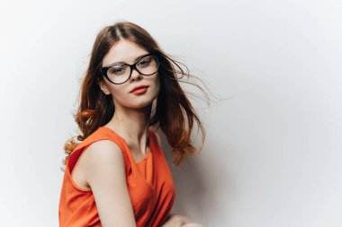 Elinde not defteri olan turuncu elbiseli bir kadın hafif arka planda bir bayan öğrenci eğitimi bilimi öğrencisi.