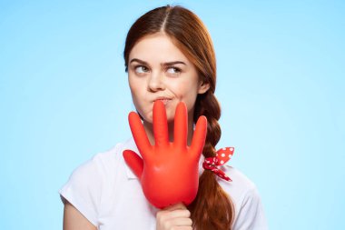 Eline lastik eldiven takmış duygusal bir kadın ev bakımı için mavi arka plan