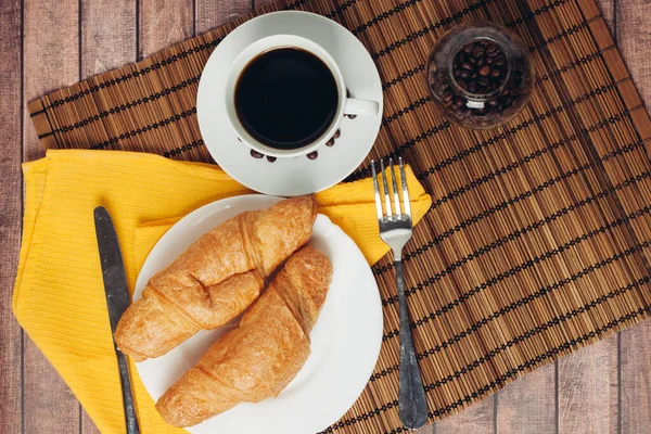 Frische Croissants auf einem Teller auf dem Tisch Frühstücksdessert — Stockfoto