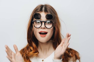 Gözlüklü güzel bir kadın kafasını tutuyor. Duygularını belli ediyor.