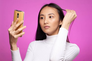 Güzel kadın Asyalı görünüm telefonu ile iletişim teknolojisi görüntülendi