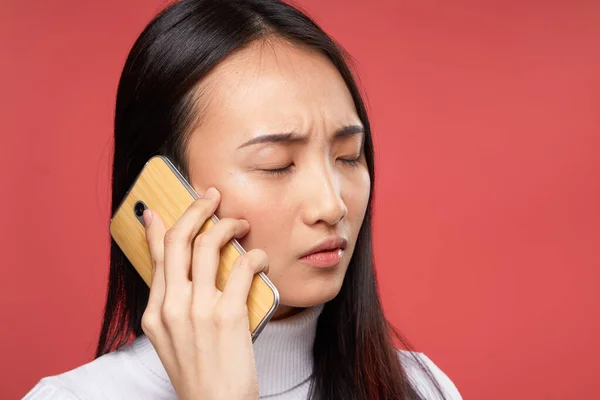 Женщина азиатская внешний вид говорить по телефону технологии образа жизни красный фон — стоковое фото