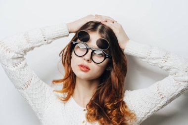 Beyaz süveter gözlüklü güzel bir kadın stüdyo çekici saçları var.