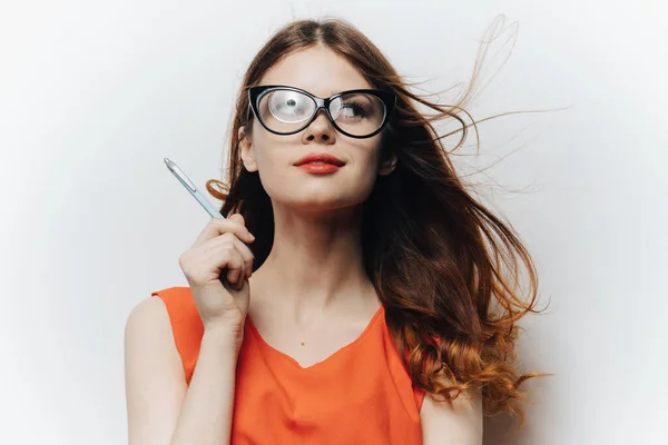 Estudante do sexo feminino em um vestido de verão e óculos fundo branco e lápis na mão — Fotografia de Stock