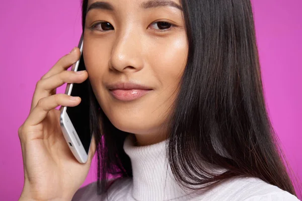 Donna asiatico aspetto telefono comunicazione internet stile di vita rosa sfondo — Foto Stock