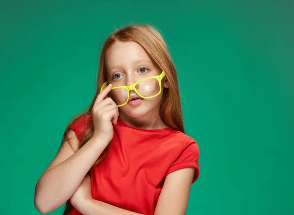 Lány piros haj és szemüveg képzés iskola zöld háttér — Stock Fotó
