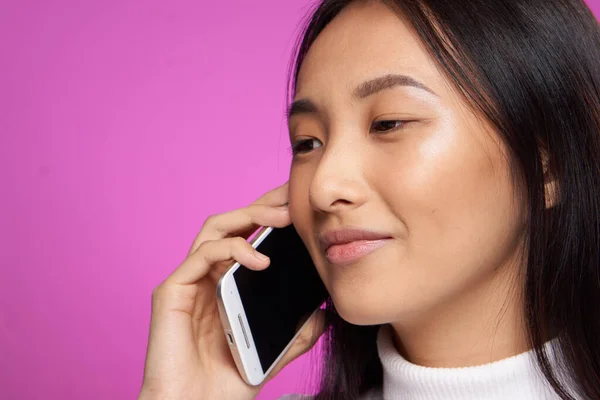 Азиатская женщина говорит по телефону обрезанный вид розовый фон — стоковое фото