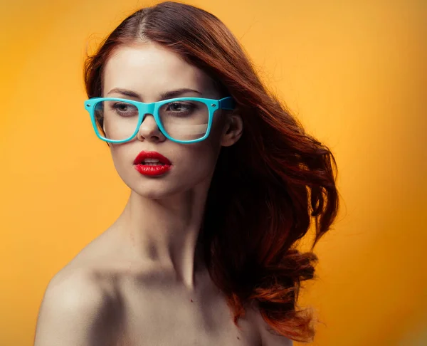 Привлекательная женщина голые плечи красные губы синие очки студия — стоковое фото