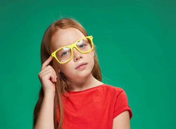 Rudowłosa dziewczyna emocje żółty okulary studio zielony tło — Zdjęcie stockowe