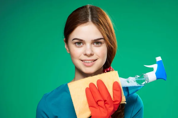 Милая уборщица резиновые перчатки моющие средства зеленый фон — стоковое фото