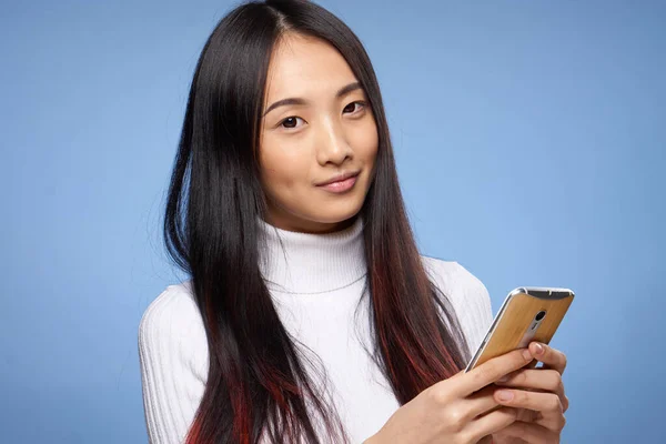 Женщина азиатской внешности с телефоном в руках интернет-технологии связи крупным планом — стоковое фото