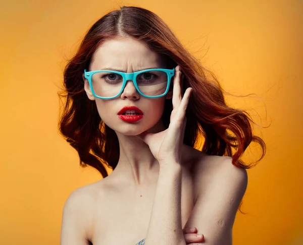 Happy woman in blue glasses with bright makeup on orange background — Stock Photo, Image