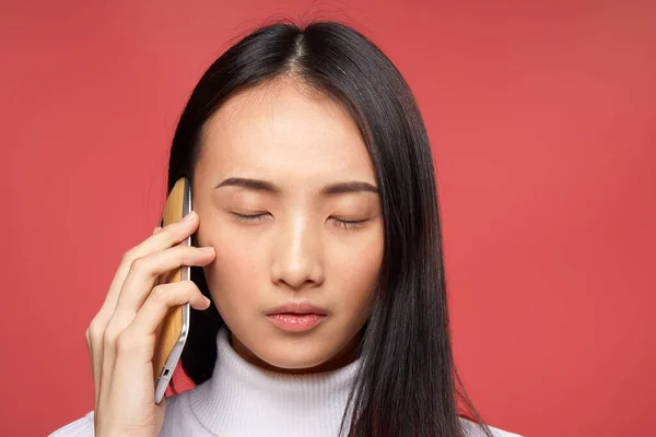 Bastante morena hablando en la tecnología del teléfono primer plano fondo rojo — Foto de Stock