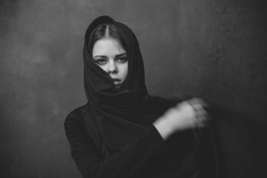 Kafasında bez olan ve elleriyle el hareketi yapan genç bir kadının portresi. Boşluğu kopyala.