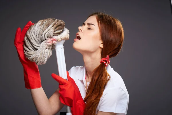 Hübsche Frau Gummihandschuhe Mopp in den Händen Emotionen dunklen Hintergrund — Stockfoto