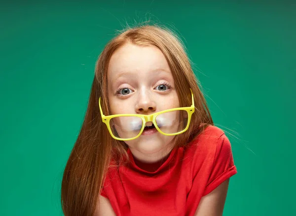 Gaie rousse fille lunettes jaunes émotions fond vert enfance — Photo