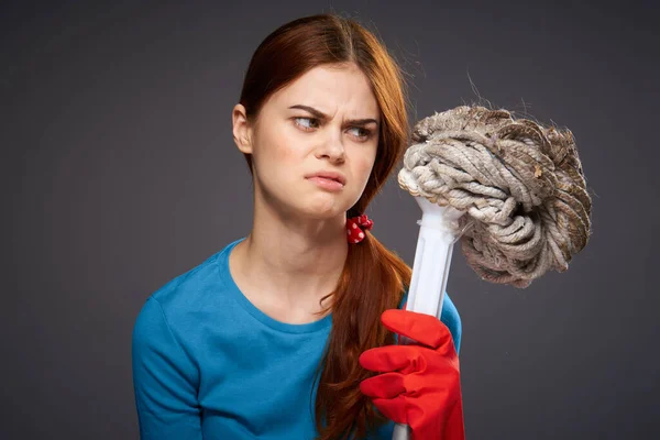 Disgruntled woman in rubber gloves mop in hands emotions dark background — Stock Photo, Image