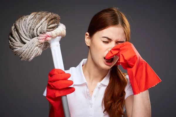 cleaning lady covers her nose with her fingers unpleasant smell mop in hand cleaning discontent