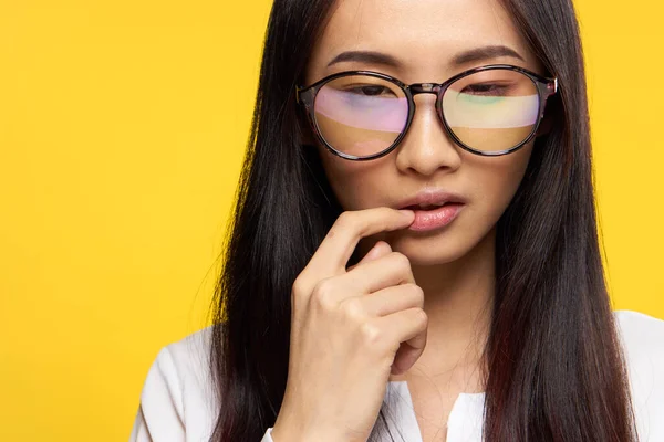 Mujer asiático apariencia elegante estilo gafas mano cerca cara amarillo fondo — Foto de Stock