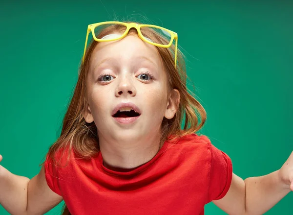 Linda chica pelirroja gafas amarillas emociones faciales escuela —  Fotos de Stock