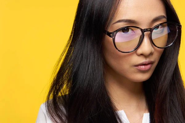 Attraktiv kvinna asiatiska utseende glasögon närbild gul bakgrund glamour — Stockfoto