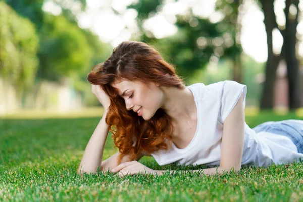 Frau liegt im Park auf dem Rasen an der frischen Luft — Stockfoto