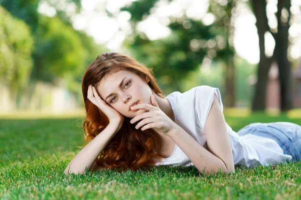 Fröhliche Frau liegt auf der Liegewiese im Park — Stockfoto