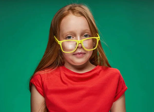 Roztomilý zrzavý dívka žluté brýle obličejové emoce škola — Stock fotografie