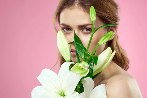 Białe kwiaty w rękach kobiet na różowym tle portret przycięty widok modelu makijaż — Zdjęcie stockowe