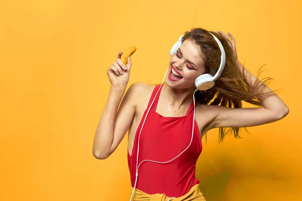 Mulher emocional em fones de ouvido brancos escuta música divertida estilo de vida fundo amarelo — Fotografia de Stock