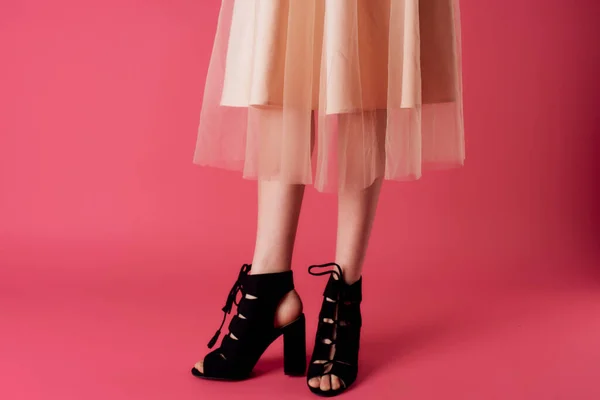 Piedi femminili nero tacchi alla moda scarpe fascino rosa sfondo — Foto Stock