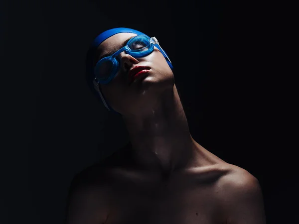 Mujer con gorra de natación y gafas sobre un fondo negro hombros desnudos —  Fotos de Stock