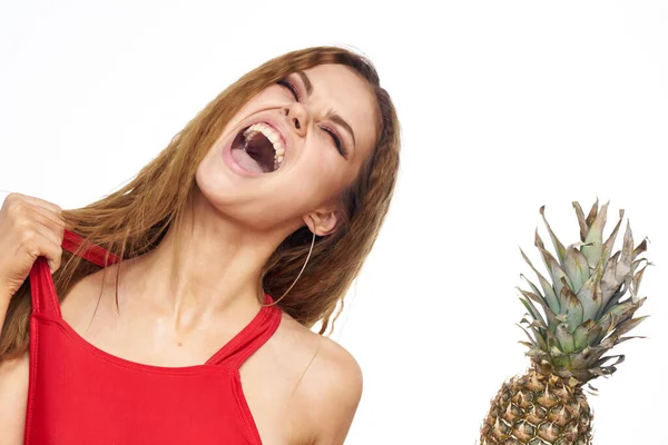 Donna con ananas in mano capelli ondulati rosso t-shirt frutta estate vacanza luce sfondo — Foto Stock