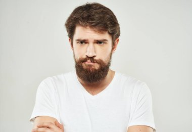 Beyaz tişörtlü sakallı adam şaşkın üzgün üzgün bak.