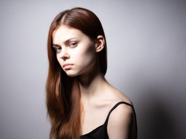 Siyah tişörtlü zarif bayan. Kızıl saçlı, üzgün surat.